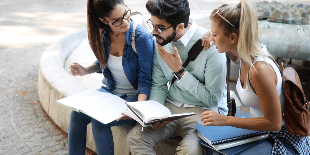 Glückliche Gruppe von Studenten, die zusammen studieren und lernen